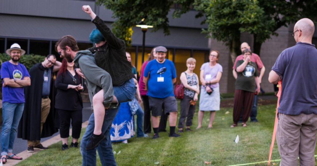 Mythmoot: An Annual Speculative Literature Conference. this photo from 2019 shows participants acting the parts of Frodo and Glorfindel's horse racing desperately to stay ahead of the Nazgul in a re-enactment of the Flight to the Ford.