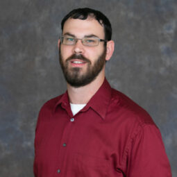 friendly looking Ryan Kimbell, glasses, beard, maroon shirt.
