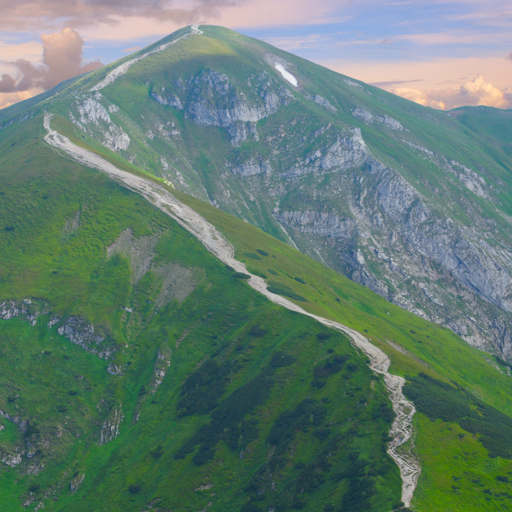 a really lovely remote mountain, verdant with a rocky summit, and a footpath leading along a ridge toward that summit