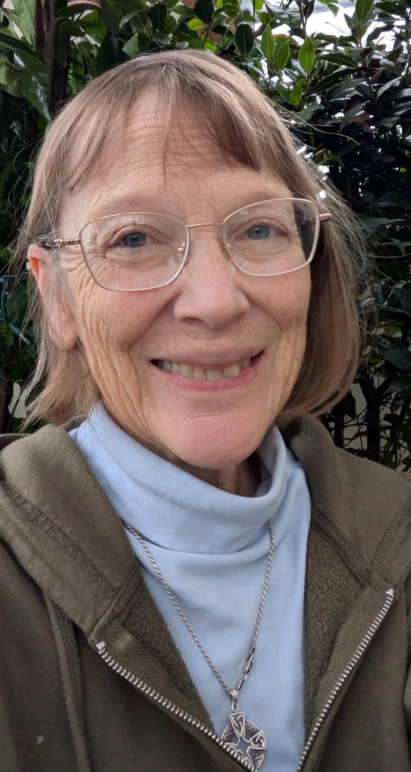 Libby Lyon's intense, curious eyes twinkle from a grandmotherly smiling face. she's dressed for chilly weather in a pale blue turtleneck and a grey overshirt.